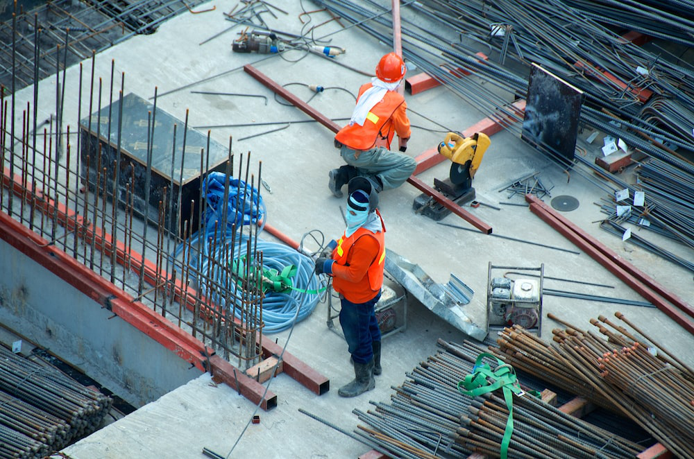 Two construction workers collaborating on-site, highlighting the role of a site safety manager in ensuring a secure work environment.