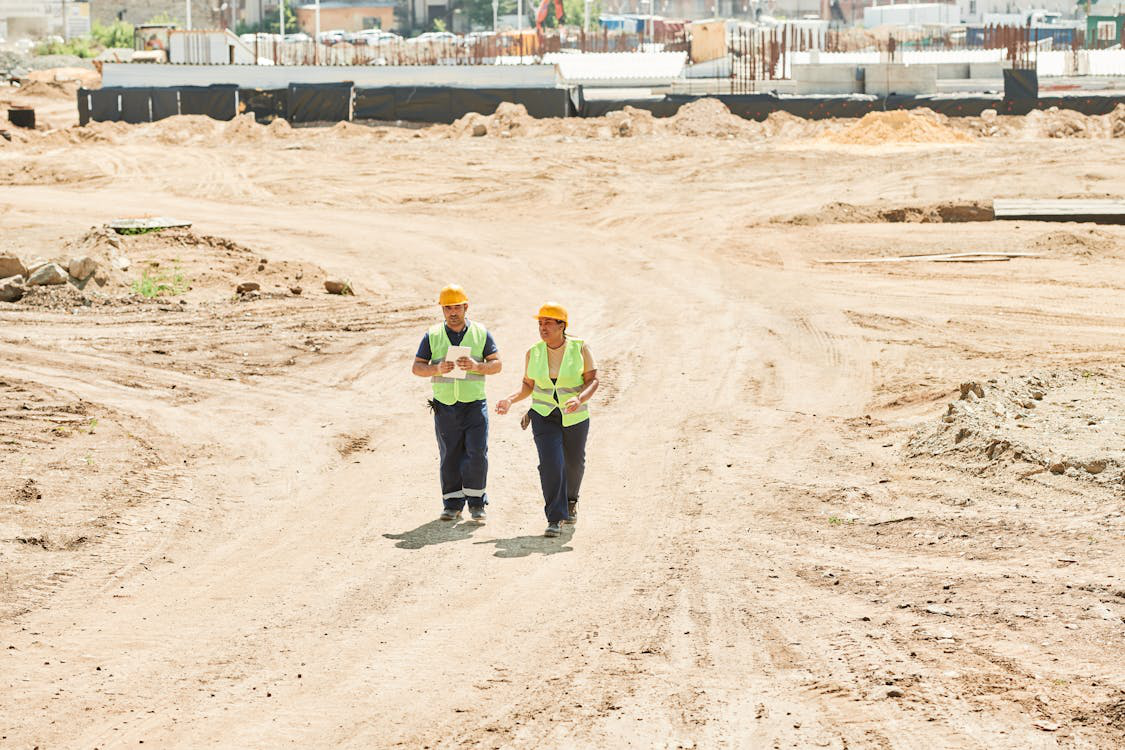 Construction safety consultant reviewing a site with a worker on a construction project.